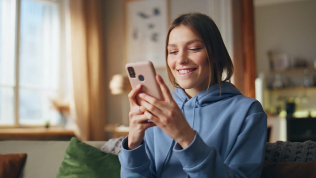 Mulher feliz olhando para o celular