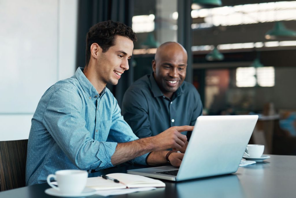 Gestores de trade marketing olhando para o computador